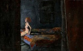 Nude woman on a bed with a quilt in a dark room
